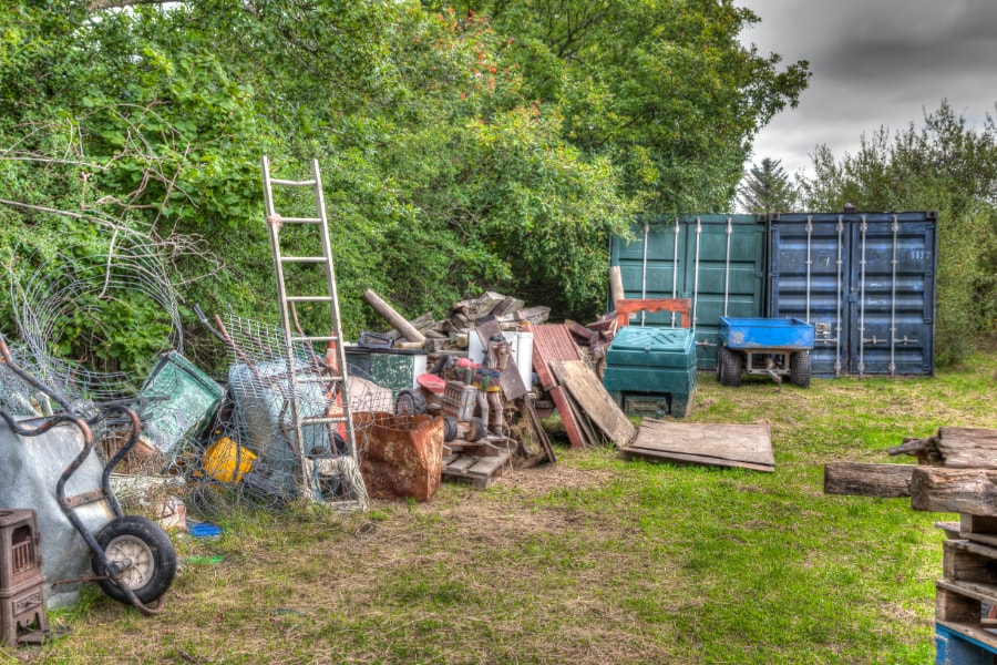 Lots of garden rubbish including ladders, wood, metal wheel barrows