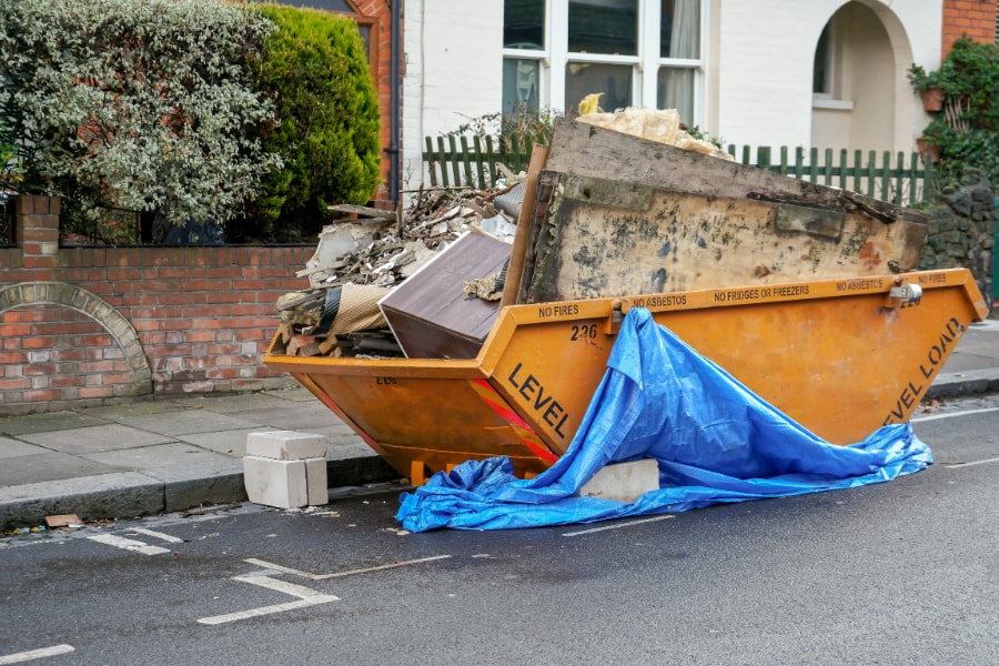 Roadside domestic skip full with household waste in Swansea